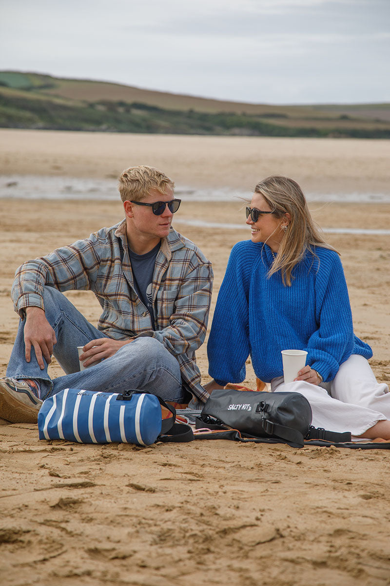 couple having a picnic on the beach with salty kit 5 litre bags