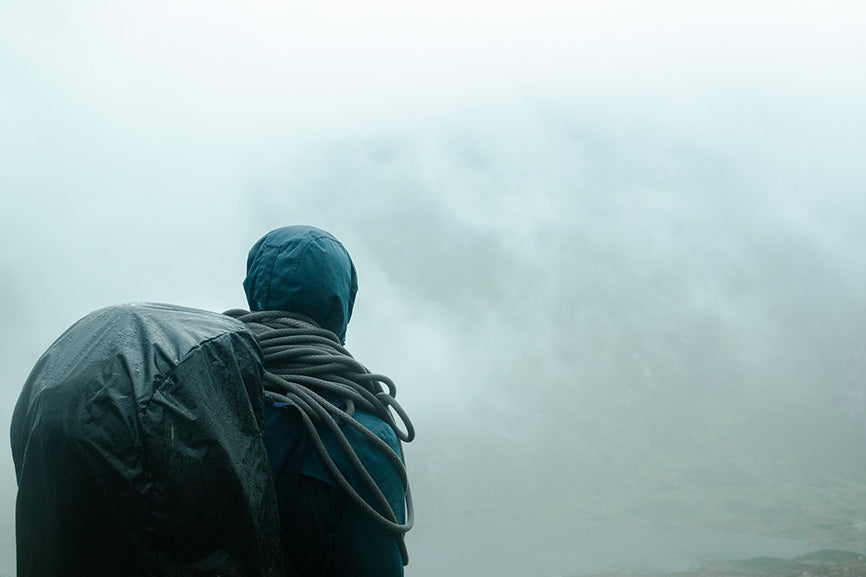 a lone hiker in the mist with a waterproof backpack on their back