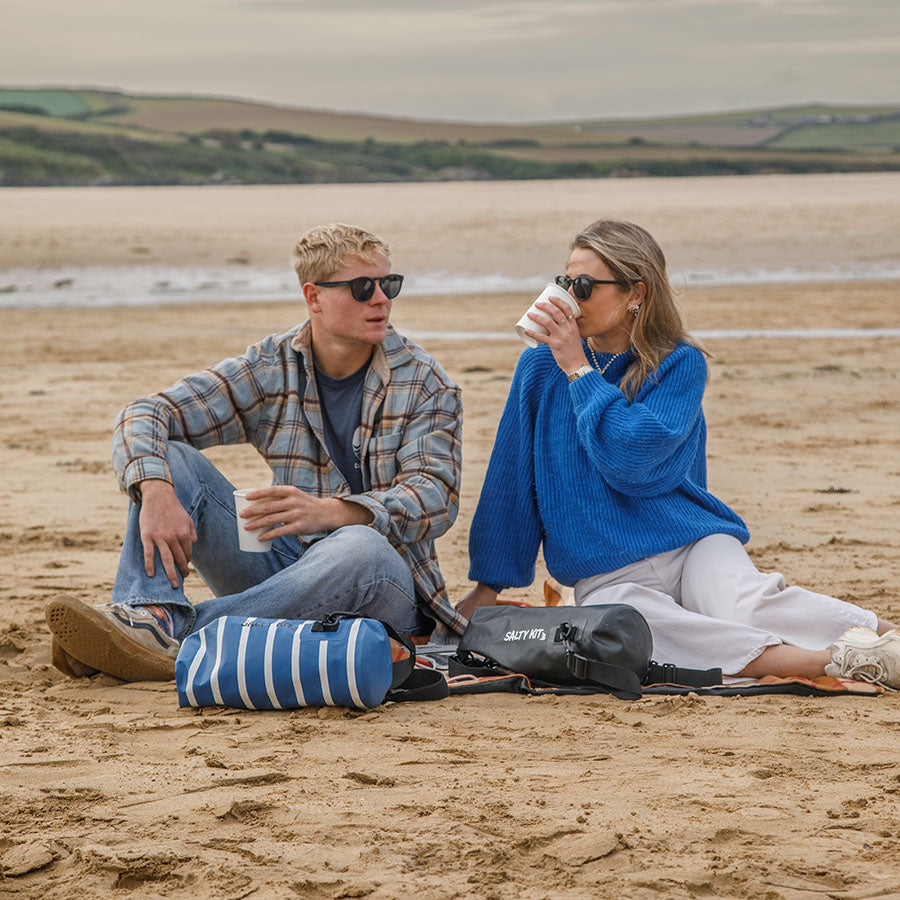couple on beach with 5 litre salty kit bags