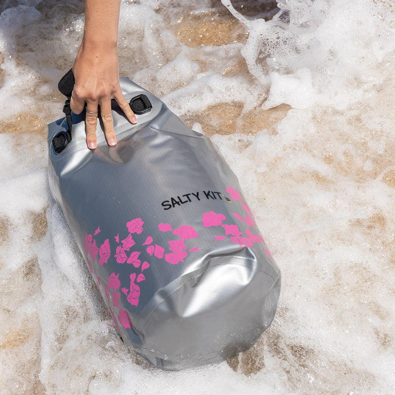 Person holding a Salty Kit dry bag in shallow water