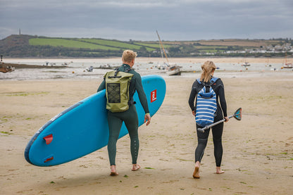 couple walking down porthilly beach wearing salty kit bags